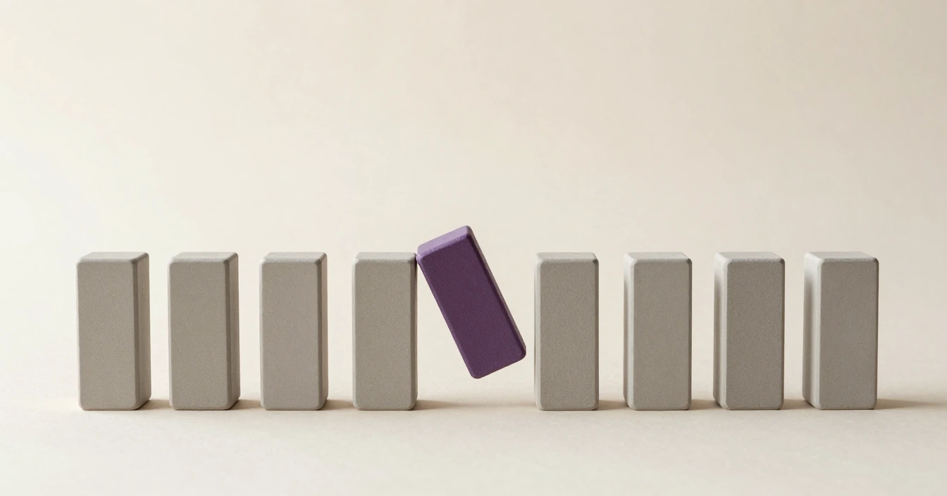 A row of plain grey blocks standing on a pale surface with one gap in it, a violet block tilting into the gap.